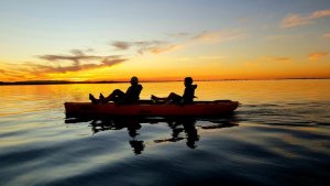 Silhouette compassduo kayak in sunset
